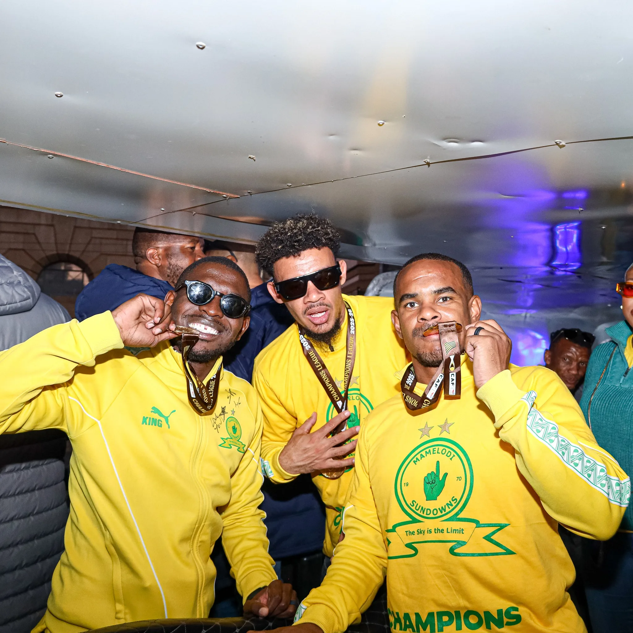 Aubrey Modiba, Williams and Rayners kissing Champions League medals