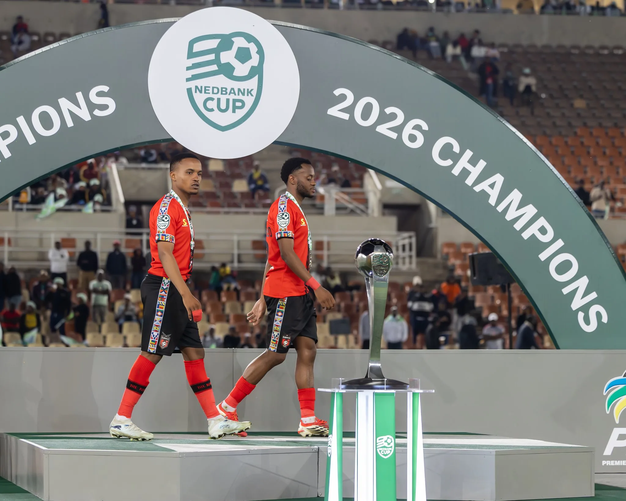 Siphesihle Maduna and Solomon Letsoanyo passing Nedbank Cup trophy