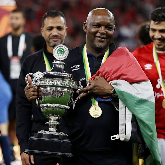 Pitso Mosimane holding CAF Super Cup trophy